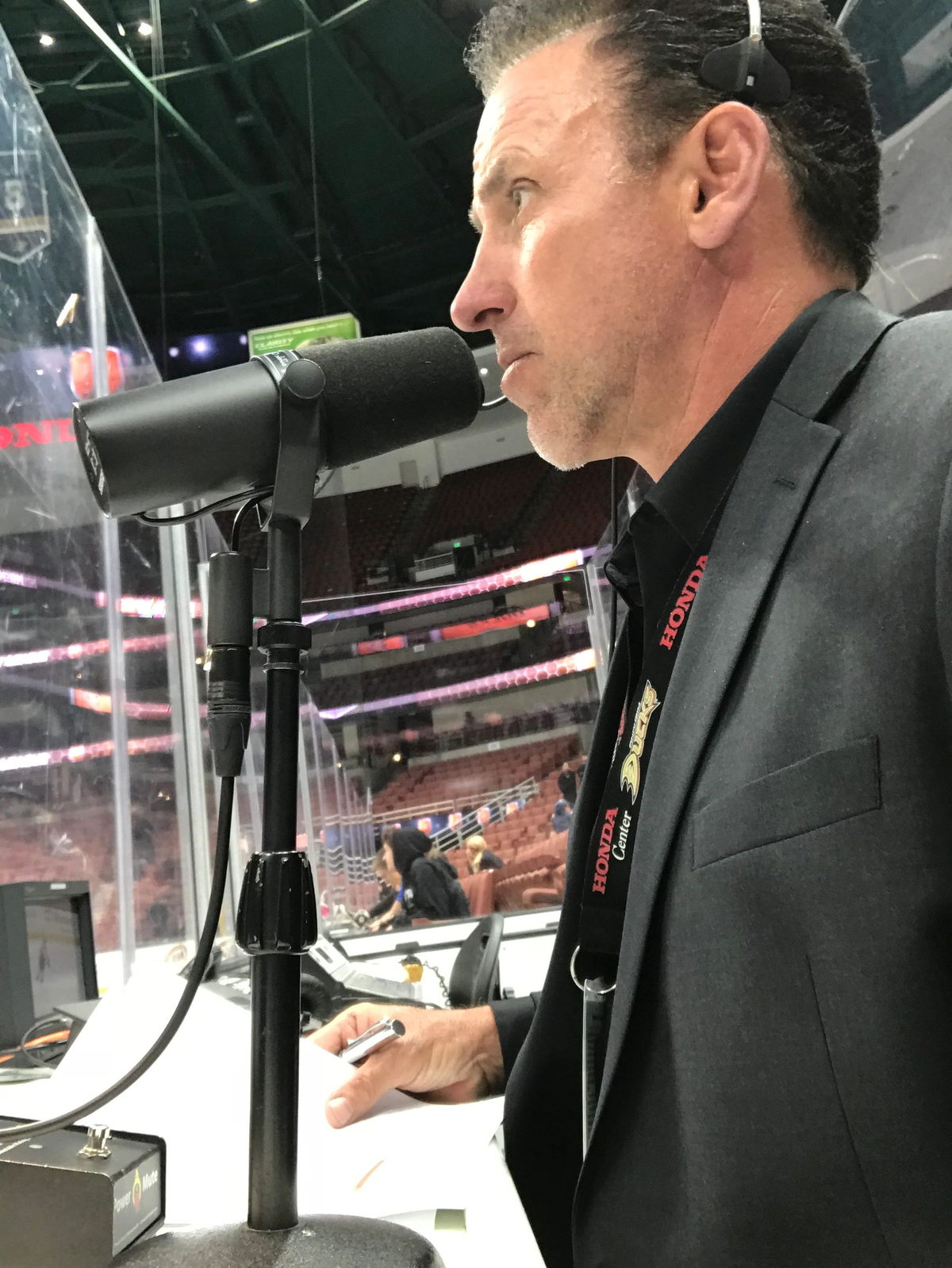 Devin Christopher announcing from an arena press box.